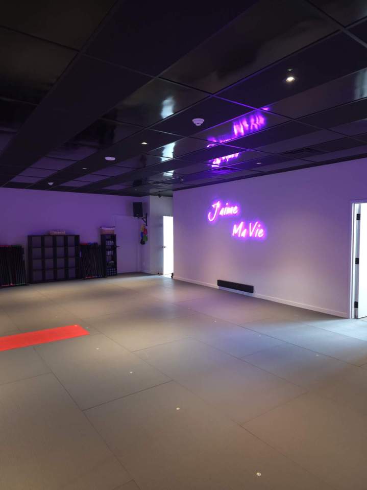 Studio de danse avec tapis de sol et rangements sur fond de néons violets Laval